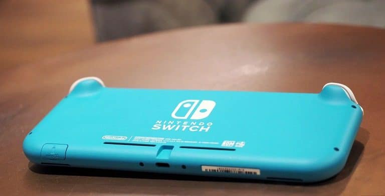 Kahverengi masasının üstünde ters duran mavi bir Nintendo Switch.