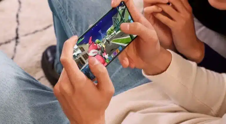 Elindeki telefonda oyun oynayan insan