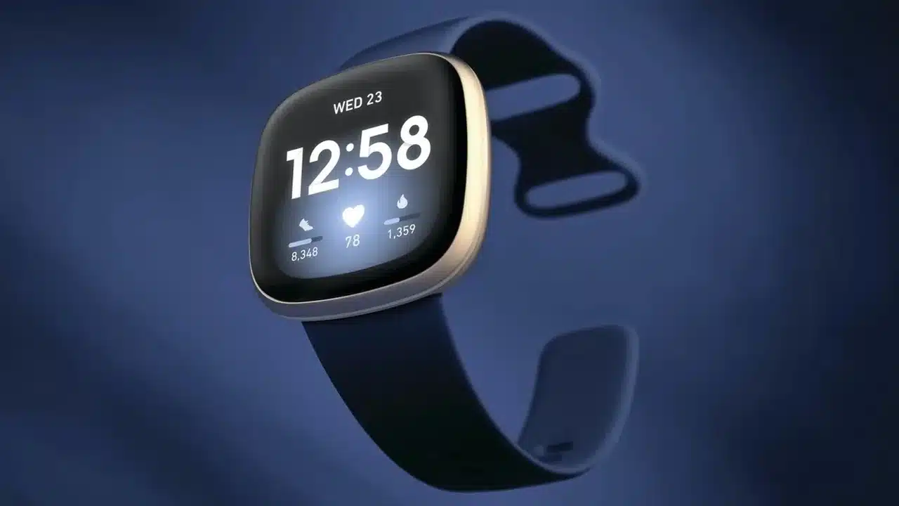 Koyu mavi zeminde ışıklı ekranıyla Fitbit akıllı saat