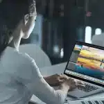 OLED ekranlı Acer Swift X 14 dizüstü bilgisayarda fotoğraf düzenleme arayüzünü kullanan kişi