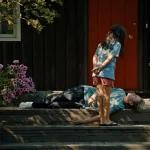 Blue Heron filminden, bir çocuğun evin verandasında yerde yatan bir yetişkine baktığı sahne